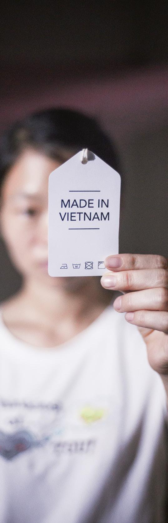 Chị Mai, công nhân may, cầm trên tay tag quần áo Made in Vietnam.