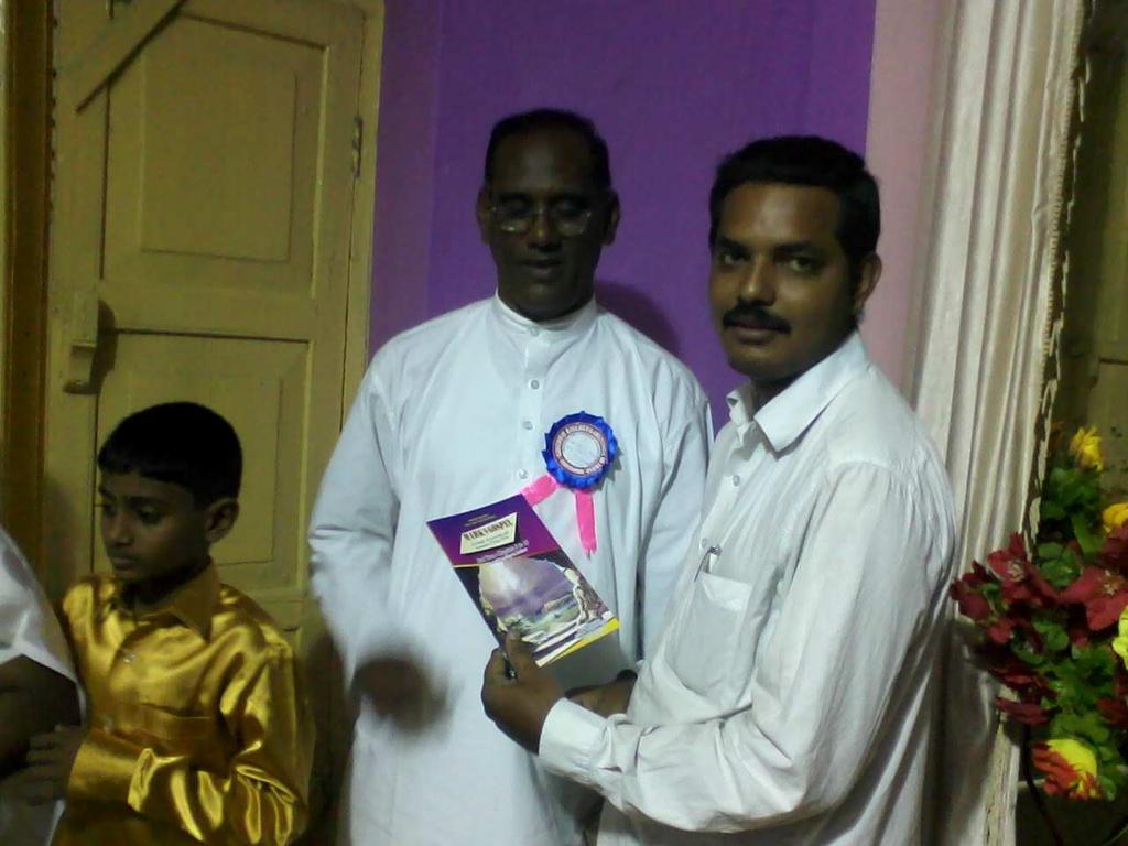 áå=fkaf^= p~íáëü _K= éêáåíéç= Satish (right) presents latest Tamil book to Amos for