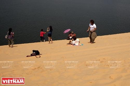 Thông tin tư liệu Bình Thuận Tháng 09 năm 2018-80 - Du khách trải nghiệm vẻ đẹp của dải cát Bàu Trắng (Bình Thuận). Bàu Trắng có 3 hồ nước trong vắt đó là : Bàu Ông, Bàu Bà và Bàu Xoài.