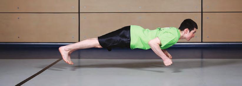 L athlète se place en position push-up en plaçant les coudes le long de son corps à un angle de 90 degrés. Les poignets et les chevilles sont raides et les poings sont fermés.